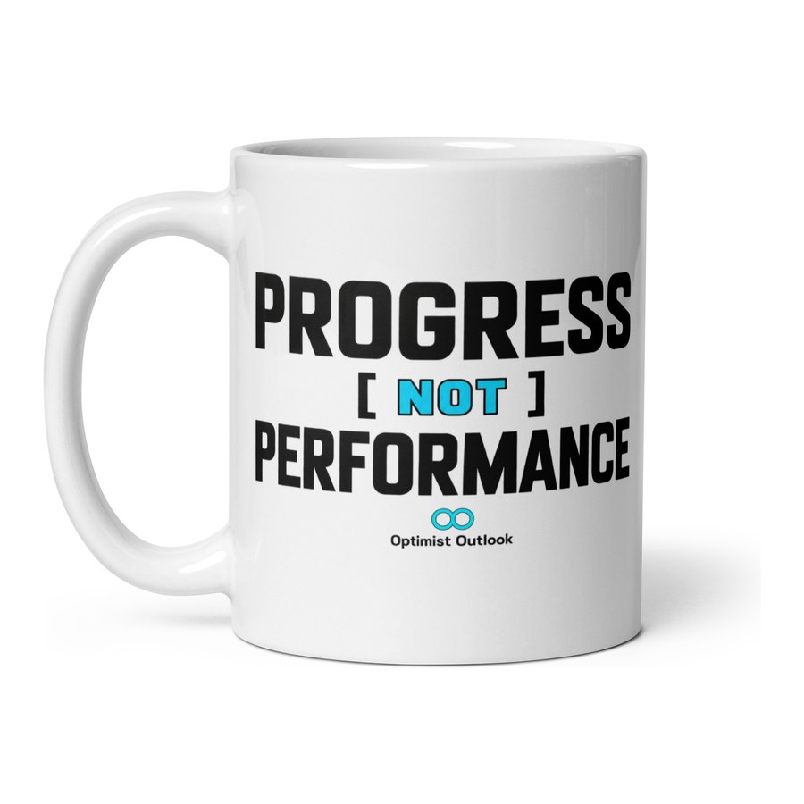 White ceramic mug printed with Progress Not Performance in black capitals, the word not highlighted in cyan.