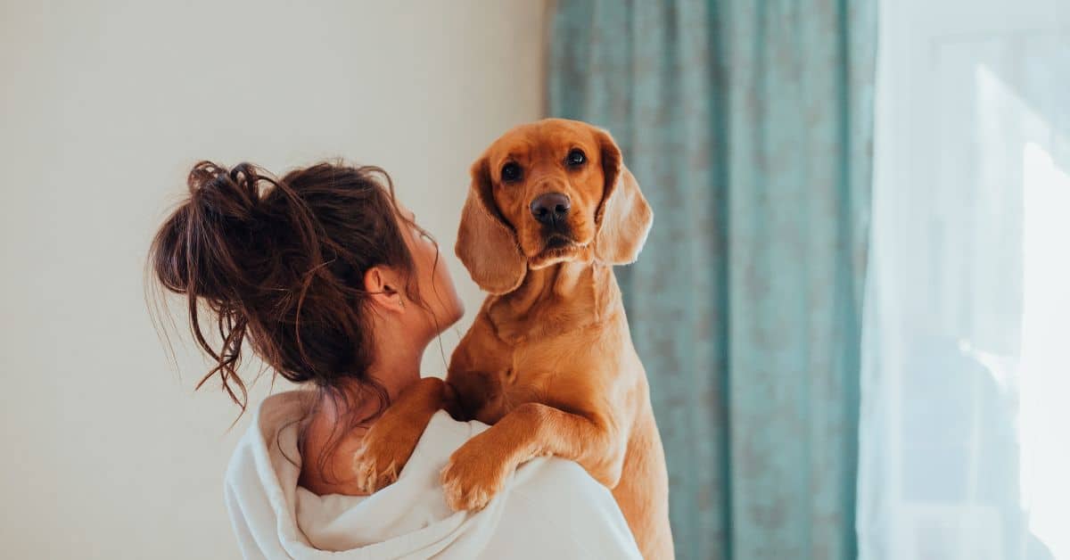 Woman cuddling dog. How interacting with animals can improve mental health