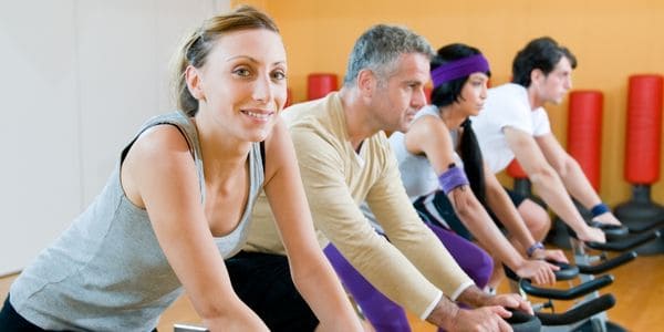 Four adults in a spinning exercise bike class exercising