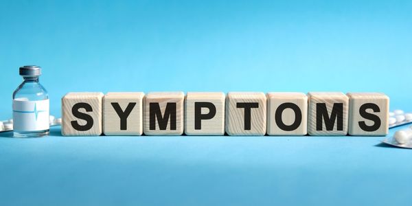 Symptoms spelled out on wooden blocks on a blue background with medicines next scattered on either side