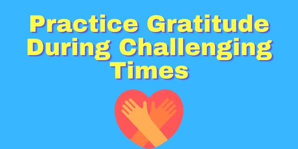 Practice gratitude during challenging times in bold yellow text on a blue background with a heart graphic with hands wrapped around hugging it.